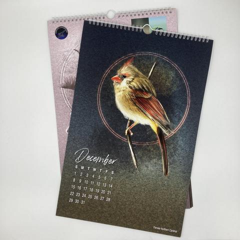 Picture of a page from an 11x17" art calendar of illustrated birds featuring a female cardinal and the month of December.