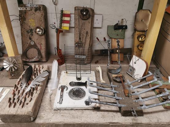 A selection of small sonic sculptures made from litter objects. They are played with animal bones and feathers.