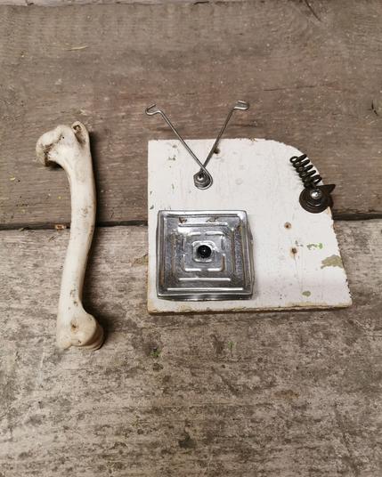 Sonic sculpture made from litter objects and an animal bone used to play it.