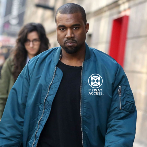 Kayne walking down the street, wearing an open blue coloured jacket, with a purposely bad white My Way Access logo photographed onto it.