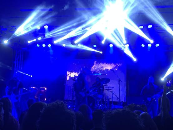 Dordeduh on stage
From left to right on stage
Bass player, painter at the back, guitarist/vocalist, drummer, guitarist.
The screen at the back shows as start of a flurry of gold-paint strokes