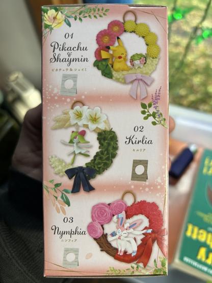 A box with various Pokémon in the center of wreathes.