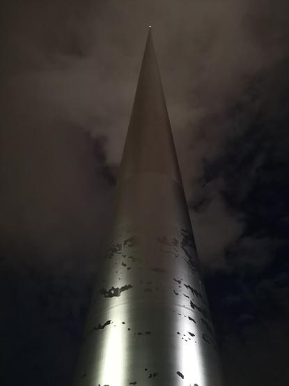 À la tombée de la nuit, et vue de son pied, The Spire Of Dublin, une pointe haute de 120 m, officiellement appelée « le monument à la lumière », située sur une grande avenue de Dublin, en Irlande.