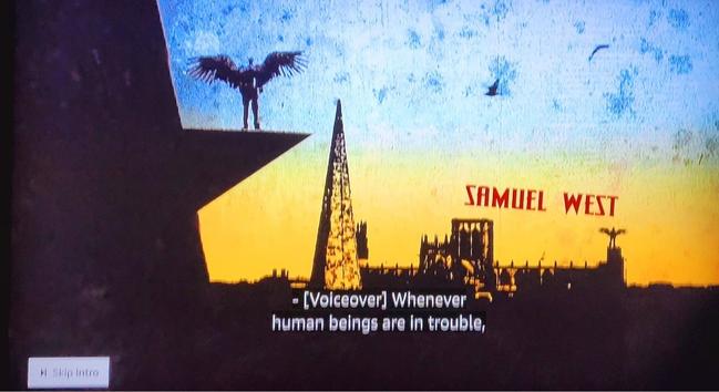 Silhouette of a church, angel with outstretched wings standing on a ledge and a tall thin pyramid shaped office building.
Samuel West
[Voiceover] Whenever human beings are in trouble.