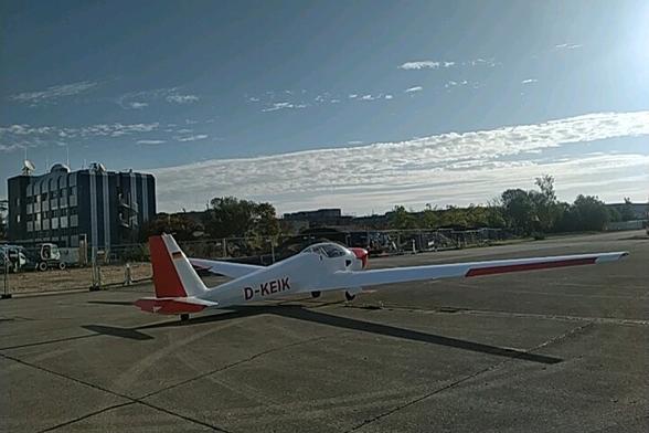 Motorglider on apron. Some bands of clouds. Sunny.