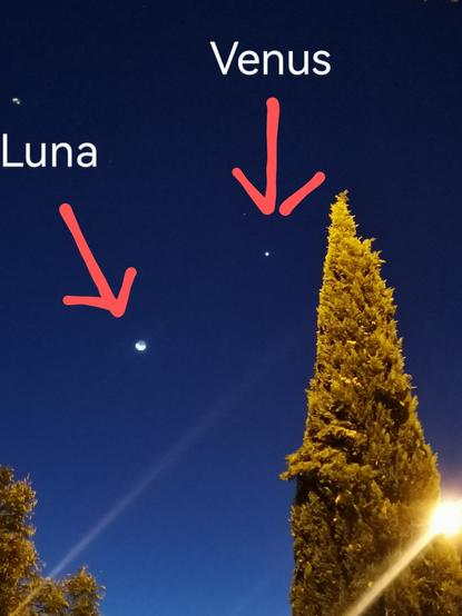 Se observa una diminuta luna cerca del centro de la foto, más arriba y a la derecha un punto luminoso menor que la luna es venus.