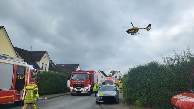 30er Zone. Rechts vor links. Hohe Hecken säumen teilweise die Kreuzung. Feuerwehrwagen sperren eine Kreuzung ab. Einsatzkräfte vor Ort. Beschädigtes Auto auf Fußweg. Krankenwagen im Hintergrund. ADAC-Rettungshubschrauber am Himmel.
Bildquelle: Polizei Cuxhaven.