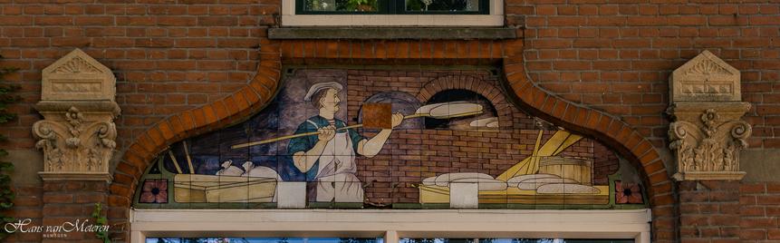 Muursteen. Een bakker schuift zijn broden in de over. Om hem heen liggen ingredienten en gereedschap