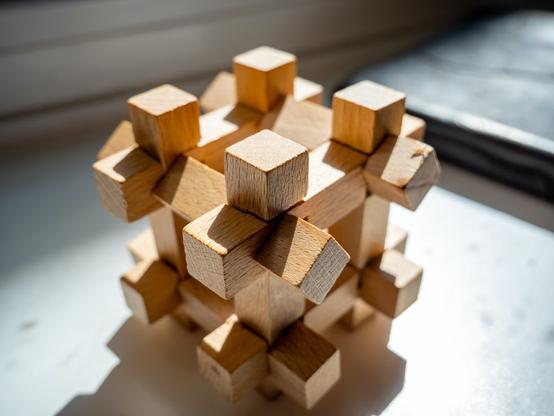 An intricate wooden puzzle with 12 interwoven beams that form a cube