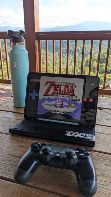 a picnic table overlooking mountain scenery with a tablet set up with the link's awakening randomizer