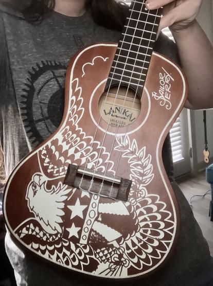 A concert ukulele incorporating a bald eagle flash design by legendary American Traditional tattoo artist Sailor Jerry.
