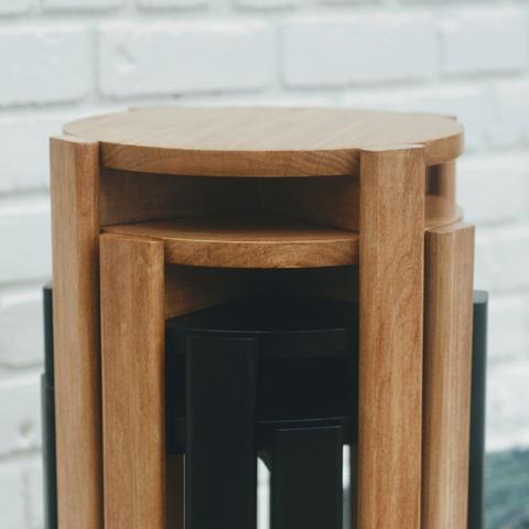 A close up of 4 poplar stools stacked and nested into each other. The top two are stained a chestnut color and the bottom two are stained black.