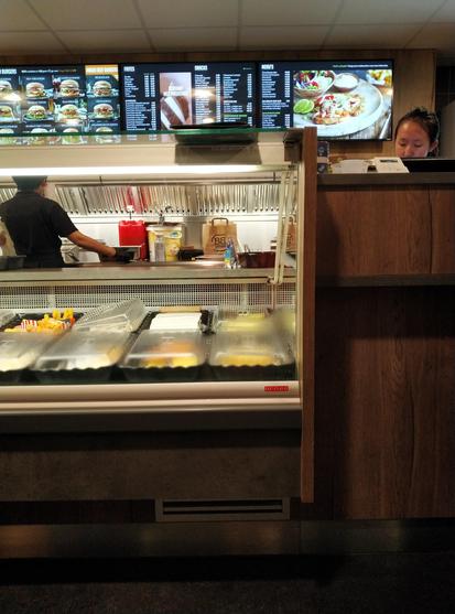 Photo of the interior of a snackbar with food behind to be prepared the window of the countertop.