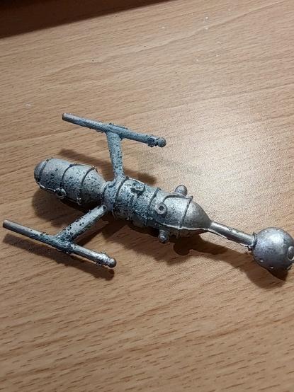 A corroded lead spaceship miniature.