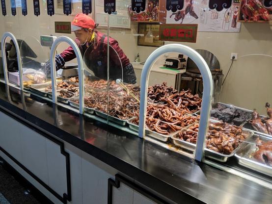 A woman working at a shop that is assorted smoked meats