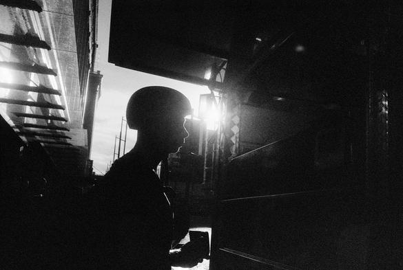 A man in silhouette approaches a food truck window.