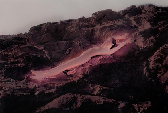 painted photo: woman like a plank, glows pink on rocks