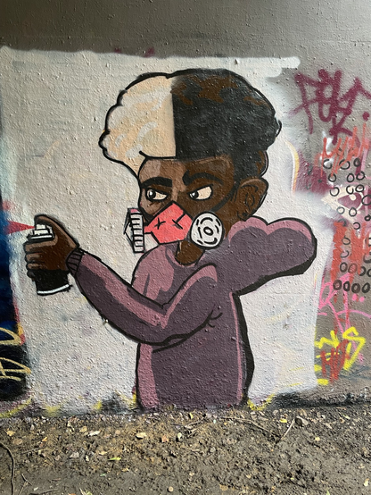 Spray with care for your health! Graffiti artist with respirator mask. Parkland walk, north london.