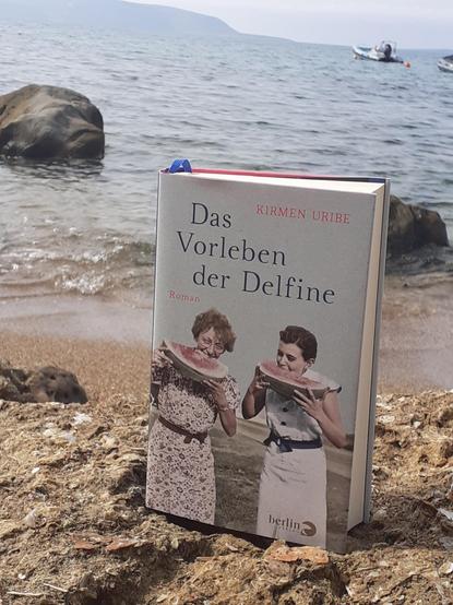 Buch, fotografiert vor Meer, auf dem Cover zwei Frauen, die in Melonenschnitze beißen