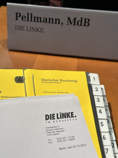 Namensschild und eine Mappe im Vordergrund