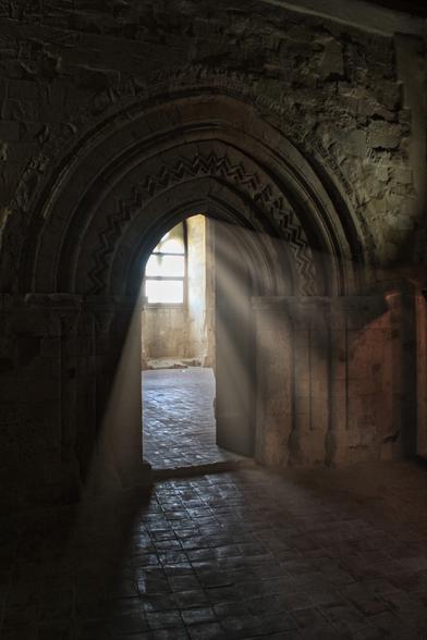 Lichtstrahlen durchfluten eine Tür im Castello di Naro