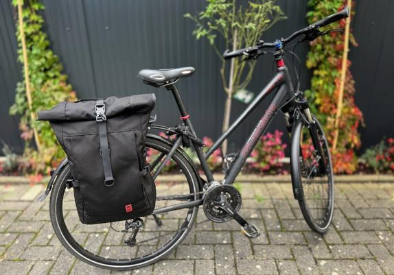 Ein schwarzer Red Rebane Purist Plus ist am Gepäckträger eines Damen-Trekkingrads montiert.