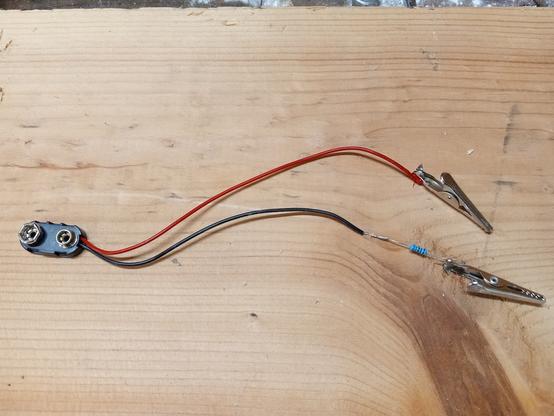 Aligator clips, a 9v battery holder, and a resistor, wired together for testing LED's.