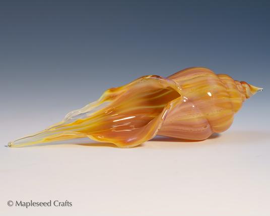 Flamework glass seashell, approximately 4 inches long, with striped colors of orange, light lavender, and clear glass. Made by me.