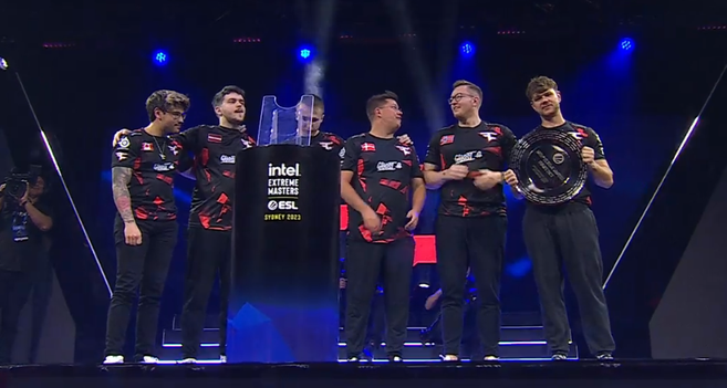 zawodnicy FaZe Clan wraz ze swoim trenerem na scenie turnieju, odbierający trofeum - srebrną paterę
