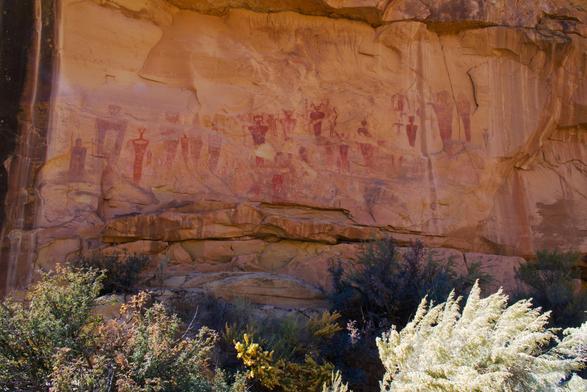 Ghostly Indigenous American pictographs showing humanoid figures on a sunny day.