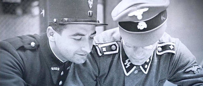 (en) Two men in uniform bend over what could be a map (out of shot). Left: French Gendarmerie with a beautiful smile; right: Waffen SS with glasses.

(fr) Deux hommes en uniforme se penchent sur ce qui pourrait être une carte (hors champ de la photo). A gauche : Gendarmerie française ; à droite : Waffen SS.