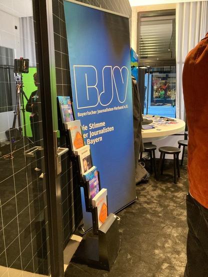 Der Stand des Bayerischen Journalisten-Verbands. Links ist ein Zeitschriften-Aufsteller mit der BJVreport und dem journalist zu sehen, rechts ist ein Aufsteller vom BJV.