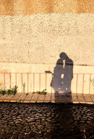 Shadow of 2 people cast on a wall by sunset light