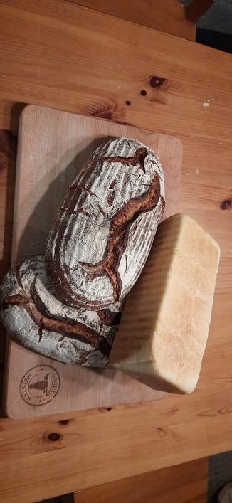 Zwei Roggenmischbrotlaibe und ein helles Weizentoastbrot
