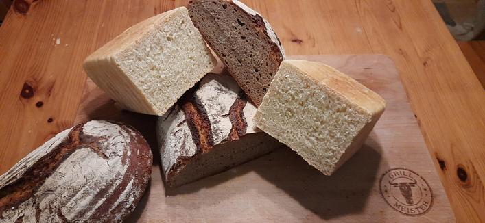 Zwei Roggenmischbrote. Eins angeschnitten sowie das Toastbrot mit Anschnitt