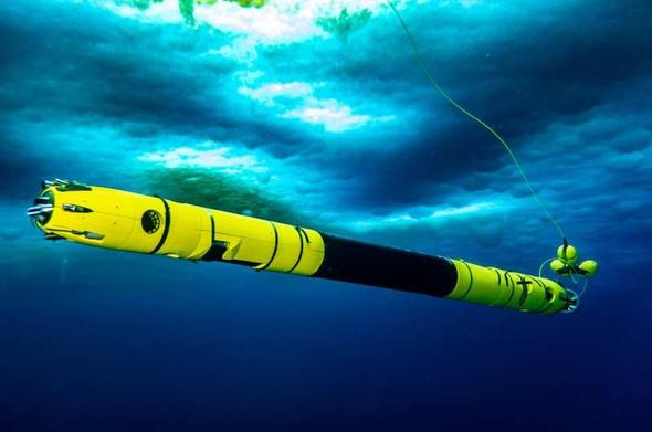photo of a long cylindrical torpedo-like robotic vehicle operating in water beneath the ice
