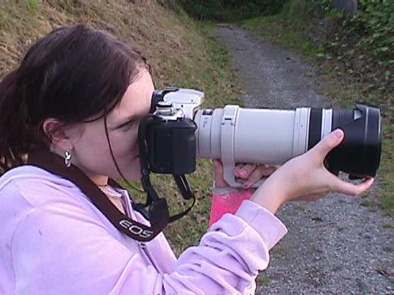 Girl holding large SLR and lens