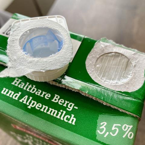 Ein Milch-Tetrapack mit abgelöstem Kunststoffverschluss.