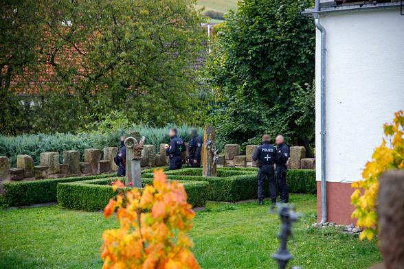 Mehrere Polizisten im Garten vom Anwesen von Thorsten Heise, rechts ein Teil des Hauses