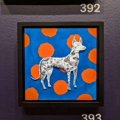 A square mixed-media portrait of a hairless dog with Posada prints on it upon a blue background with orange flowers.