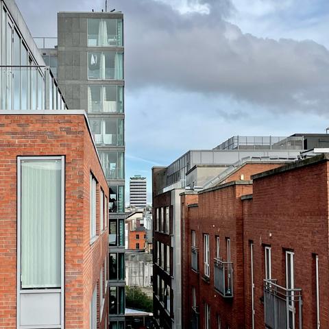 View from a roof down through a streets’ buildings, creating a vista of Liberty Hall modern tall building in Dublin.