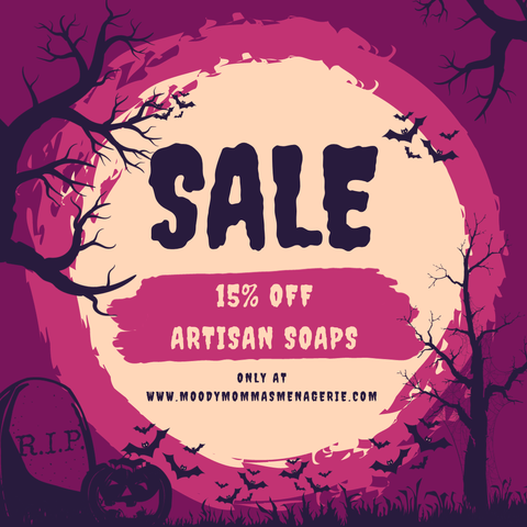 A Sale add with spooky font on a yellow circle that reads "Sale. 15%off Artisan Soaps. Only at www.MoodyMommasMenagerie.com" Behind the yellow circle are two deep pink circles in varying shades. Bats fly from the right of "SALE" with spooky trees, jack-o-lanterns and a tombstone