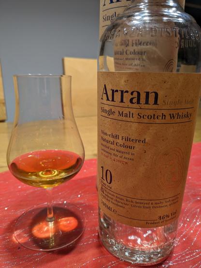 An empty whisky bottle of Arran 10 years old, to the left a nosing glas with the remains what was in the bottle.

Behind the empty bottle the paper tube it came in can be seen.