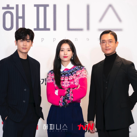Actors Park Hyung Sik, Han Hyo Joo, & Jo Woo Jin standing in front of the 2021 South Korean drama “Happiness” logo.