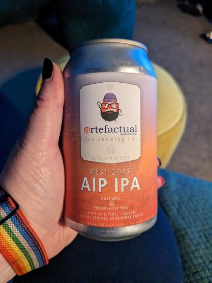 A hand holding a can of Artefactual AIP IPA