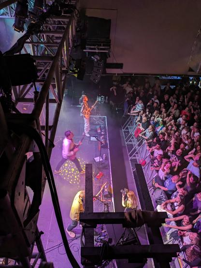 A photo of the brilliant Corella performing to a massive crowd, taken from above and backstage with the light rigging in view.