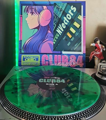 A green with pink splatter vinyl record sits on a turntable. Behind the turntable, a vinyl album outer sleeve is displayed. The front cover shows an anime girl wearing headphones and a mixer board. 

To the right of the album cover is an anime figure of Yuki Morikawa singing in to a microphone and holding her arm out.