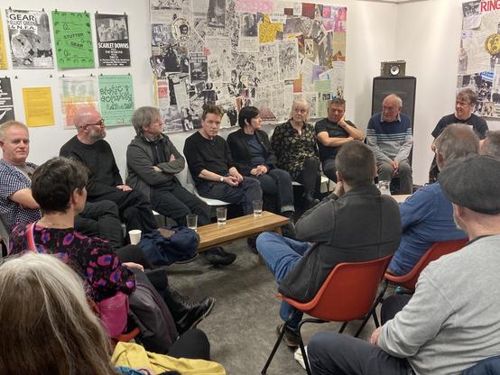 An art space with a panel of men and women talking about DIY culture in a small market town. The place is packed with people listening & asking  questions.
