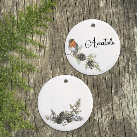Décoration de Noël : disque en céramique à suspendre au motif de rouge-gorge et de pommes de pin à personnaliser avec le prénom de votre choix. A retrouver dans notre boutique en ligne : ernestine-etcie.fr