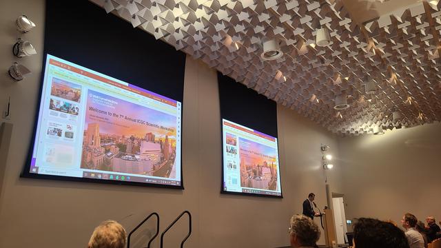 Olivier Elemento, director of the Englander Institute of Precision Medicine at Weill Cornell Medicine, giving the opening remarks of the conference. Two panels on the wall  show the presentation